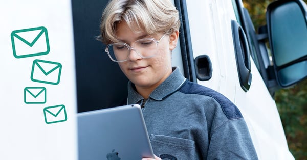 På fotot syns en person i glasögon med rågblont hår och en laptop i knät. Personen sitter i dörröppningen till en skåpbil.