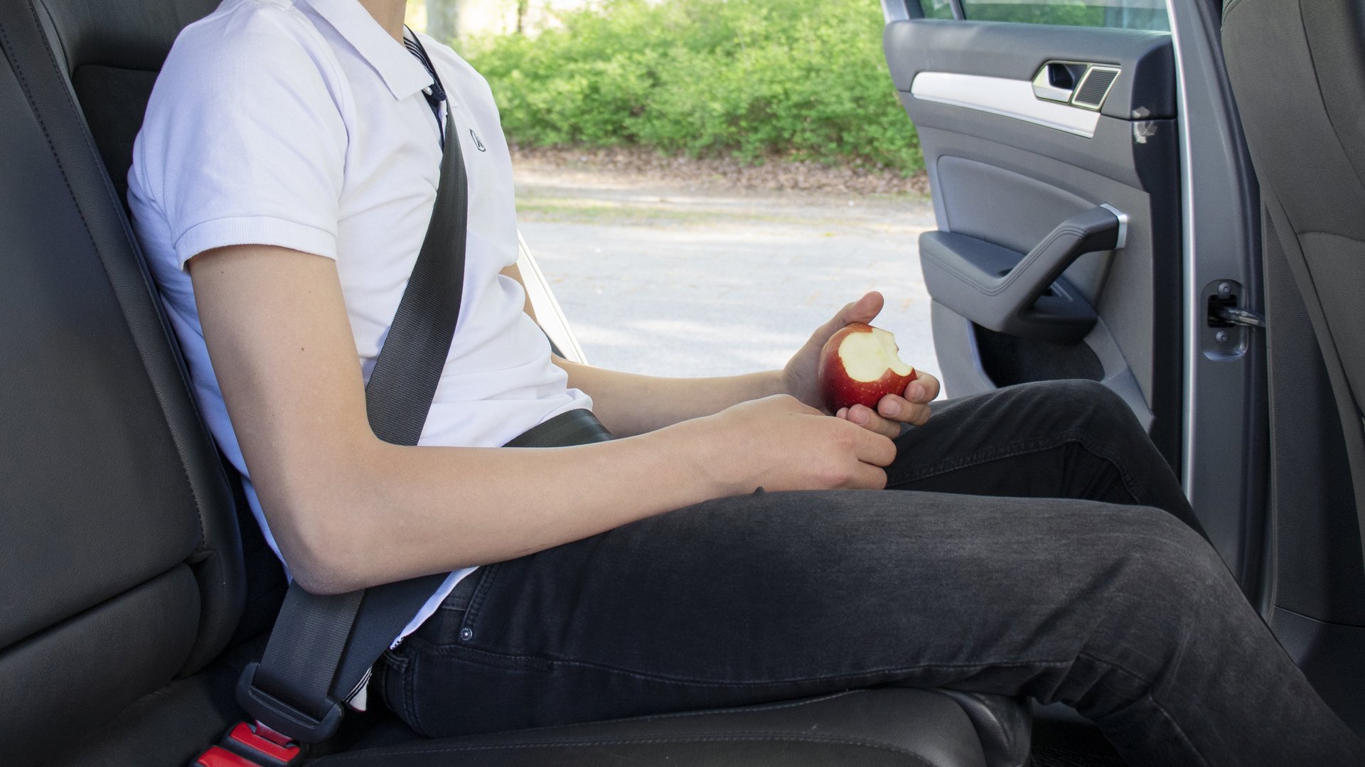 Pojke i baksätet på en bil, fastspänd med säkerhetsbälte