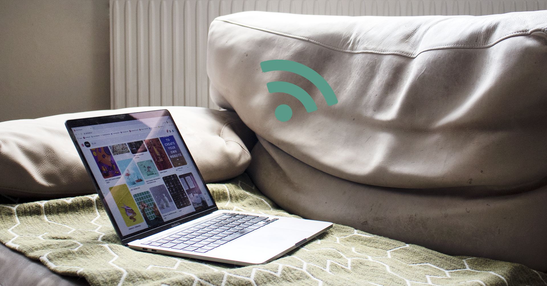 På bilden syns en öppen laptop som ligger på en ljusgrön soffa. Jämte soffan syns en WiFi-symbol i grönt.
